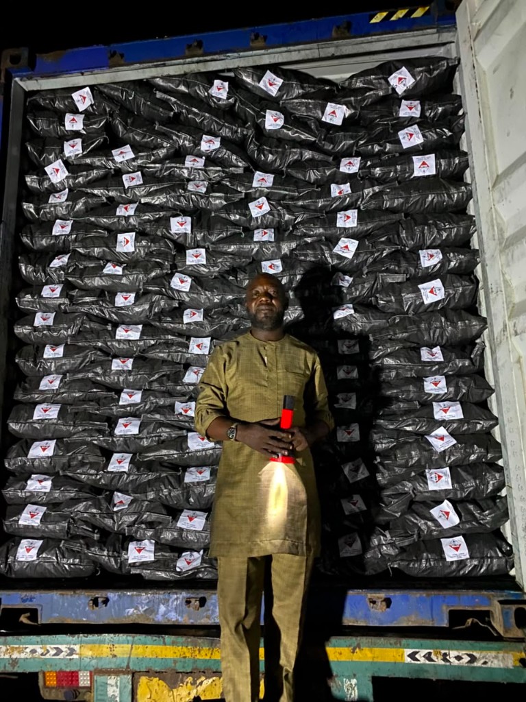 A loaded container of bagged charcoal at night