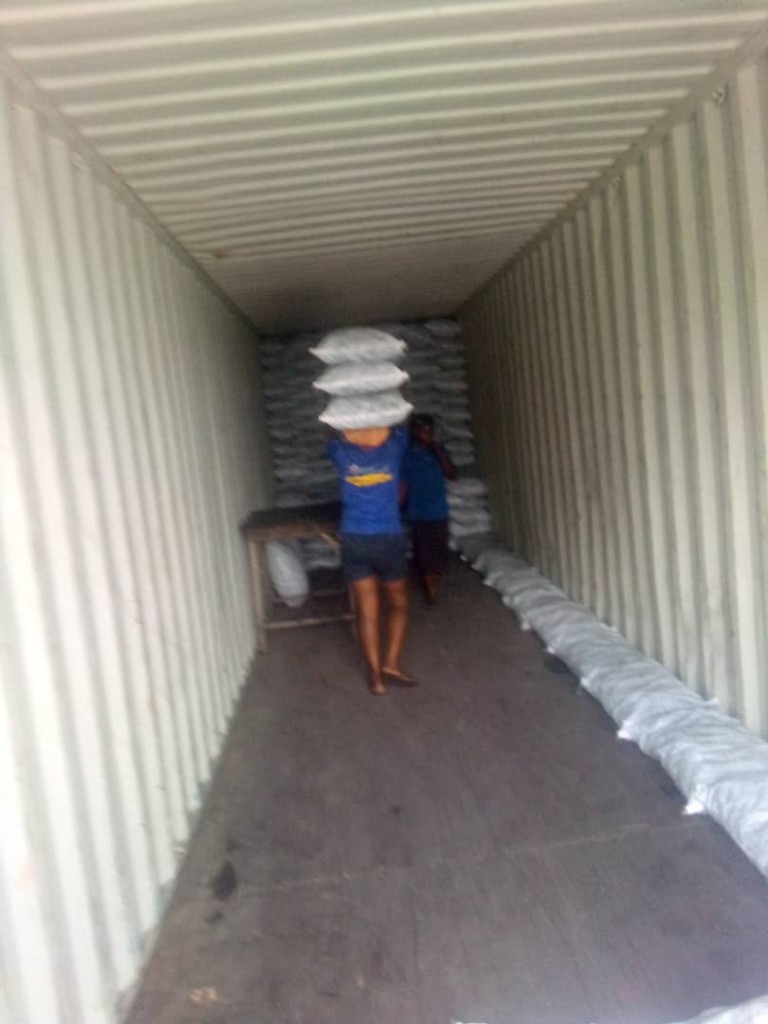Sacks being carried into a container