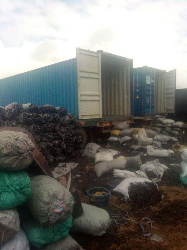 Charcoal sacks beside open shipping containers